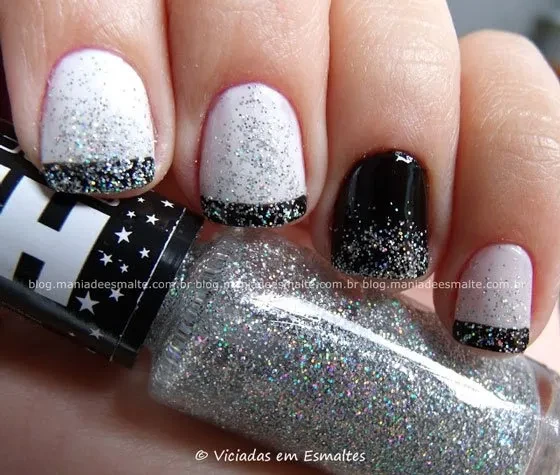 Unhas decoradas preto e branco com glitter prata em close, mostrando a francesinha e a filha única preta